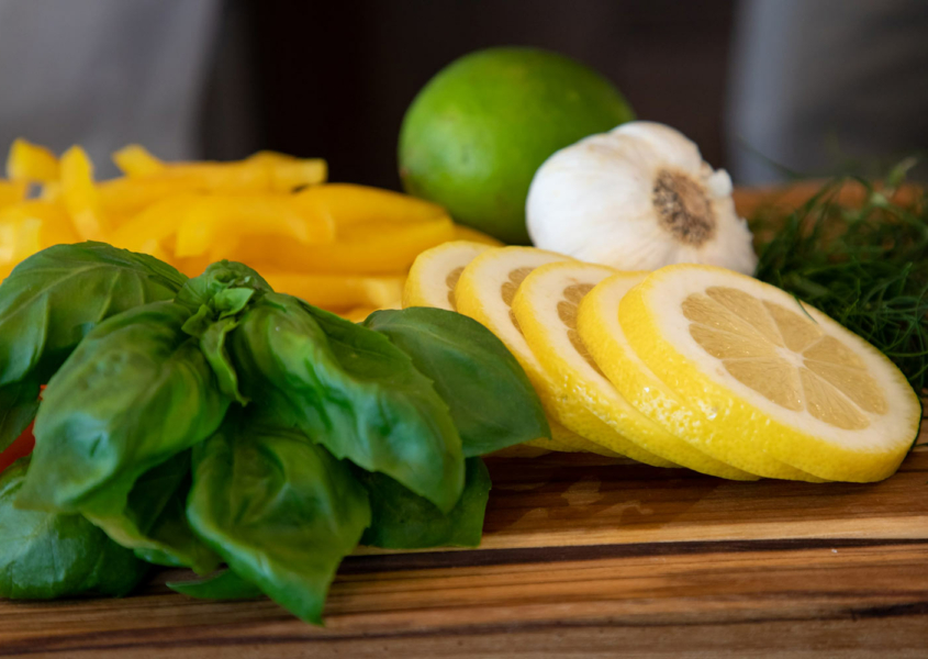 Lemon and basil on a wooden cutting board.