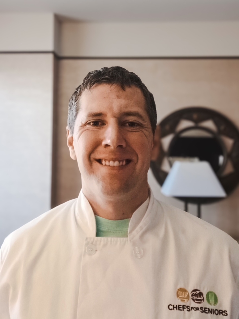 Chefs for Seniors Green Valley local owner Ben Dezso headshot in white chef coat